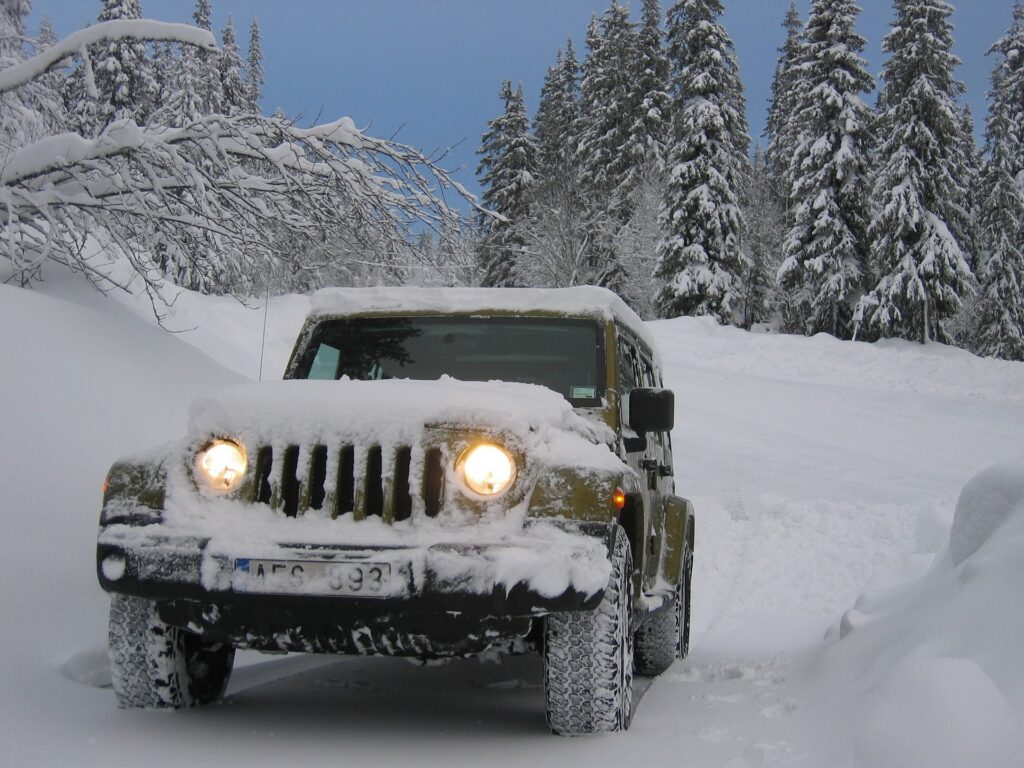 Snow cover jeep against a snow covered hill. Blog graphic for blog post for awomansoutlook.com.